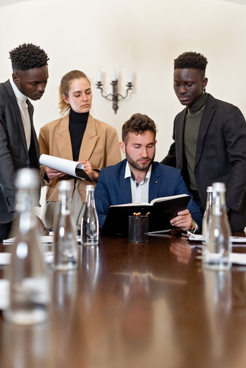 A diverse group of professionals collaborating in a modern office conference room setting.